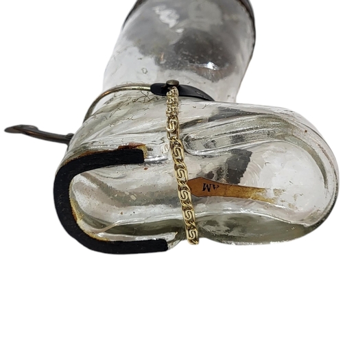 116 - AN EARLY 20TH CENTURY CONTINENTAL NOVELTY MUSICAL GLASS DECANTER MODELLED AS A RIDING BOOT, CIRCA 19... 