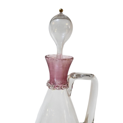 121 - AN EARLY 20TH CENTURY MURANO DECANTER AND STOPPER
With mounted pink flashed rim and base, having han... 