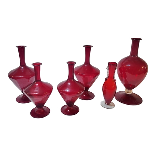 125 - A SET OF TWELVE MURANO EARLY 20TH CENTURY IRON RED GLAZED WINE CARAFES 
One with ribbed spiralling g... 