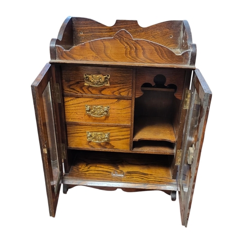 144 - A LATE VICTORIAN SOLID OAK SMOKER’S CABINET 
With galleried top above two bevelled glazed doors encl... 