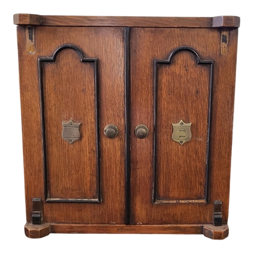 145 - A LATE VICTORIAN SOLID OAK SMOKER’S CABINET 
The two doors enclosing two short and one long drawer, ... 