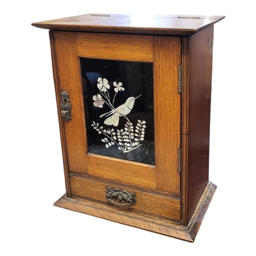 146 - A LATE VICTORIAN OAK SMOKER’S CABINET
With rise and fall top, single door inset with foil bird panel... 