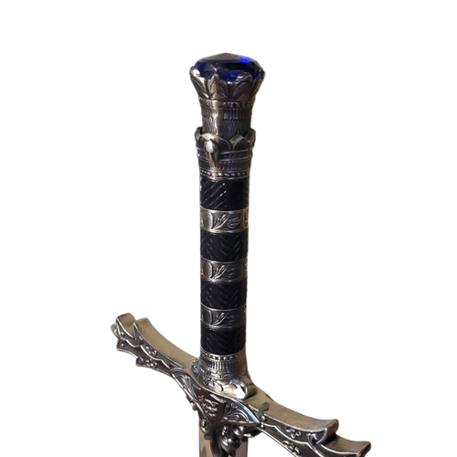 156 - A THEATRICAL POLISHED AND PATINATED STEEL SWORD
With faux sapphire inset pommel.
(119cm)