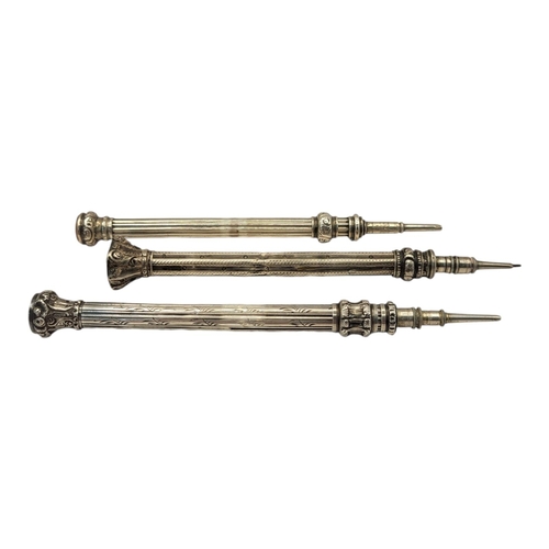 32 - A COLLECTION OF THREE VICTORIAN WHITE METAL PROPELLING PENCILS
To include a shield form finial with ... 