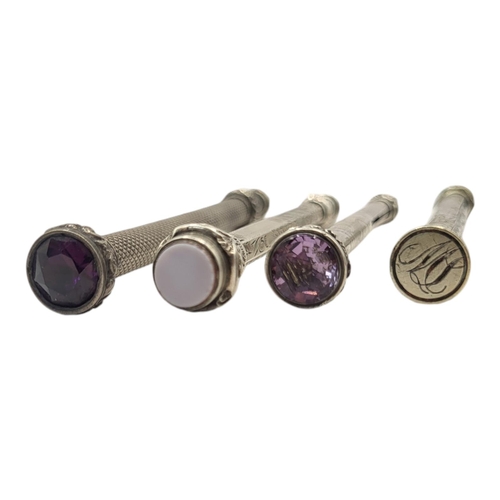 34 - A COLLECTION OF FOUR VICTORIAN WHITE METAL PROPELLING PENCILS
To include a round cut amethyst finial... 