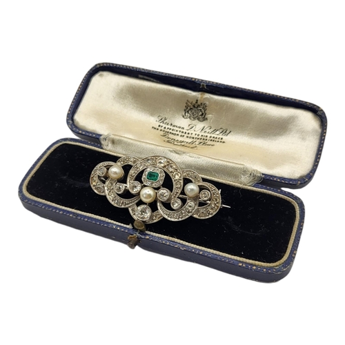 57 - AN EARLY 20TH CENTURY WHITE METAL DIAMOND, EMERALD AND PEARL BROOCH 
Of Belle Époque form with centr... 