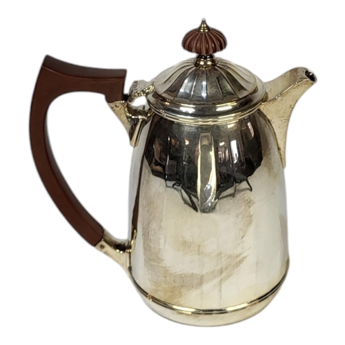 69 - AN EARLY 20TH CENTURY SILVER COFFEE POT
Having a carved wooden finial and chamfered design to body, ... 