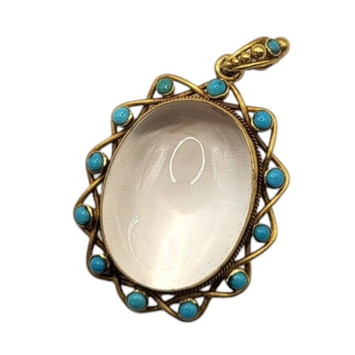 86A - A 19TH CENTURY YELLOW METAL, TURQUOISE AND ROCK CRYSTAL PENDANT
The cabochon cut central stone in a ... 