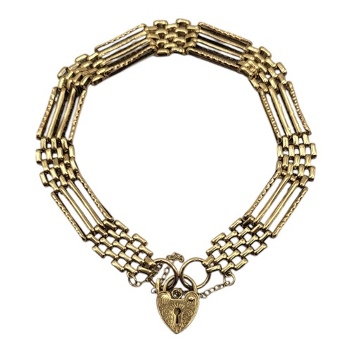 70A - AN EARLY 20TH CENTURY 9CT GOLD GATE BRACELET
Four pierced bars with heart form locket clasp.
(approx... 