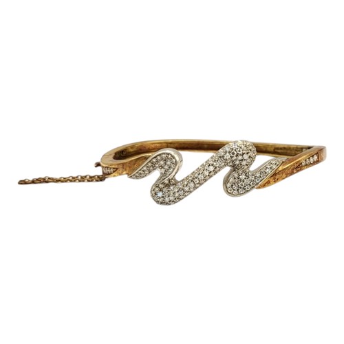 2B - A VINTAGE YELLOW METAL AND DIAMOND ‘LIGHTENING’ BANGLE
Having an arrangement of pave set diamonds an... 