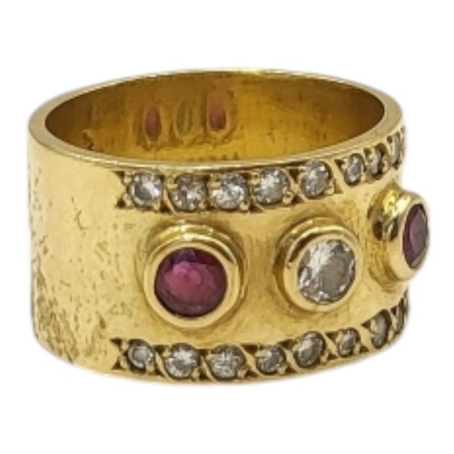 4B - A YELLOW METAL, RUBY AND DIAMOND THREE STONE RING
The central round cut diamond flanked with rubies,... 