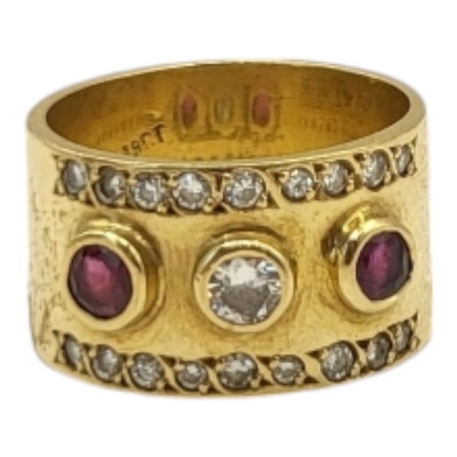 4B - A YELLOW METAL, RUBY AND DIAMOND THREE STONE RING
The central round cut diamond flanked with rubies,... 