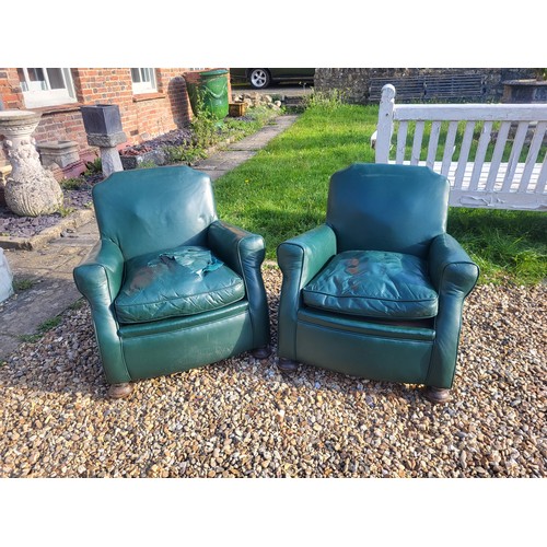 497 - A PAIR OF 1920/30’S CLUB ARMCHAIRS
In green leather upholstery, complete with loose cushions, on bun... 