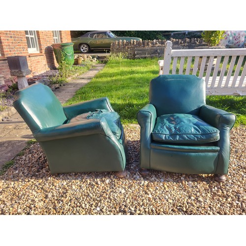 497 - A PAIR OF 1920/30’S CLUB ARMCHAIRS
In green leather upholstery, complete with loose cushions, on bun... 