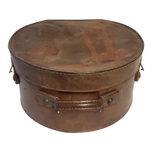 499 - AN EARLY 20TH CENTURY BOLIVIAN STITCHED TAN LEATHER HAT BOX
Containing a ladies’ black velvet wide b... 