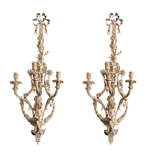 195 - A PAIR OF LOUIS XVI STYLE GILT BRONZE CHERUB THREE LIGHT WALL SCONCES
The acanthus scrolling arms st... 