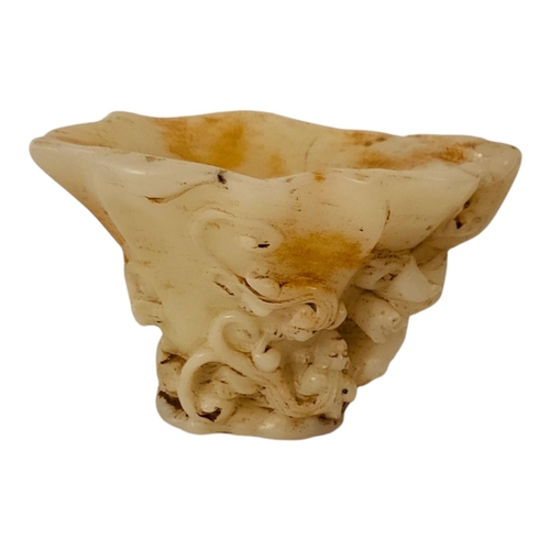 228 - A CHINESE WHITE JADEITE LIBATION CUP
With carved tiger and acanthus decoration.
(16cm x 11cm x 11cm)... 