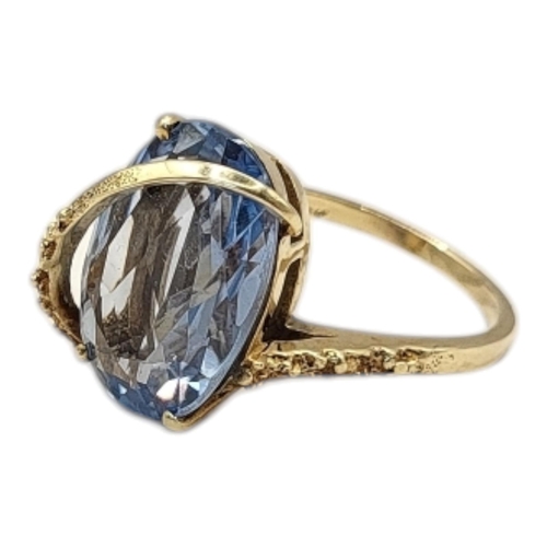 46 - A VINTAGE 10CT GOLD AND AQUAMARINE RING
The oval faceted cut stone set in a textured gold mount.
(si... 