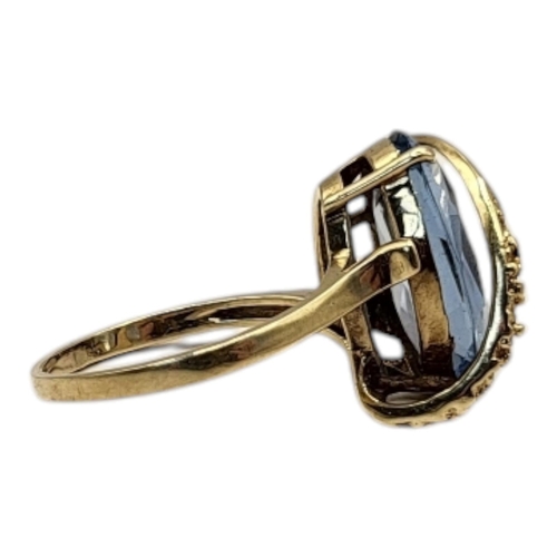 46 - A VINTAGE 10CT GOLD AND AQUAMARINE RING
The oval faceted cut stone set in a textured gold mount.
(si... 