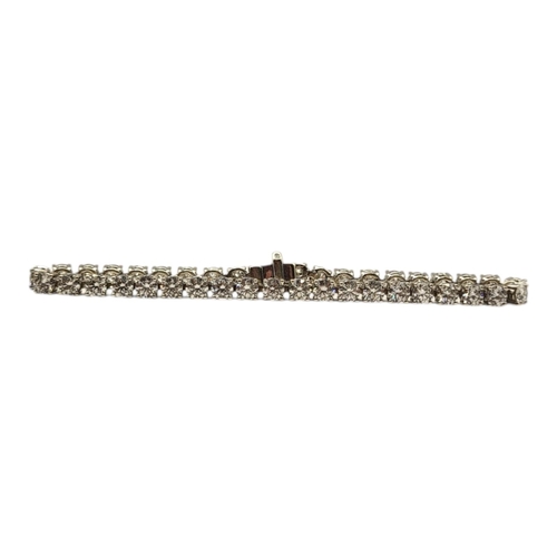 79 - AN 18CT WHITE GOLD AND DIAMOND TENNIS BRACELET
The single row of round cut diamonds, in a fitted vel... 