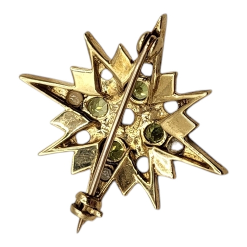 102A - AN EARLY 20TH CENTURY 9CT GOLD, PERIDOT AND SEED PEARL STAR BROOCH
Having an arrangement of seed pea... 