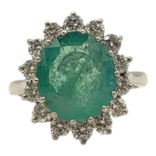 19 - AN 18CT GOLD, EMERALD AND DIAMOND CLUSTER RING
The central oval faceted cut emerald edged with round... 