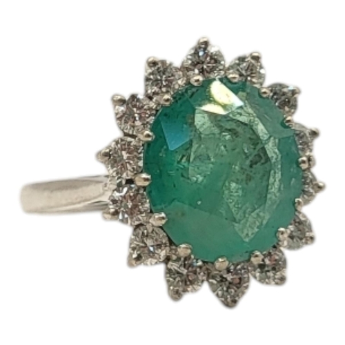 19 - AN 18CT GOLD, EMERALD AND DIAMOND CLUSTER RING
The central oval faceted cut emerald edged with round... 