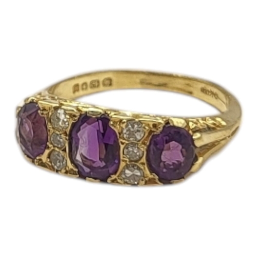 52 - A VINTAGE 18CT GOLD, AMETHYST AND DIAMOND THREE STONE RING
The graduated oval cut amethyst stones in... 