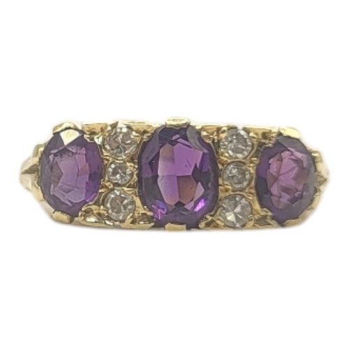 52 - A VINTAGE 18CT GOLD, AMETHYST AND DIAMOND THREE STONE RING
The graduated oval cut amethyst stones in... 