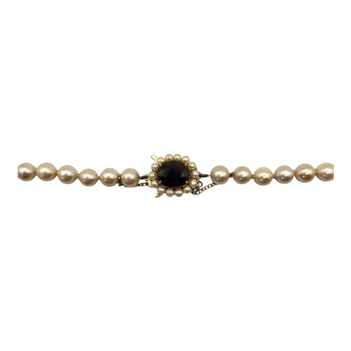 57 - A 9CT GOLD, GARNET, SEED PEARL AND PEARL NECKLACE
The oval cut garnet edged with pearls with a singl... 