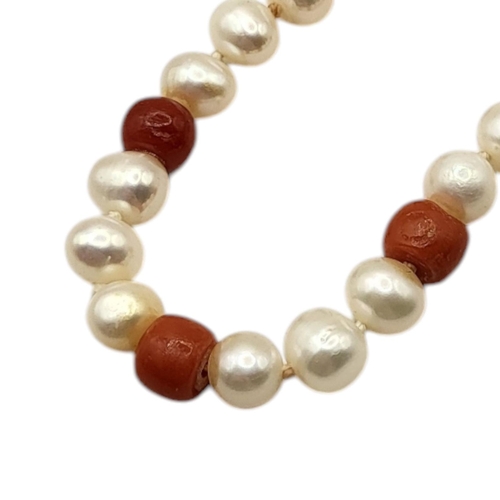 60 - A CHINESE 14CT GOLD, CORAL AND PEARL NECKLACE
Coral beads interspersed with pearls on a 14ct gold cl... 