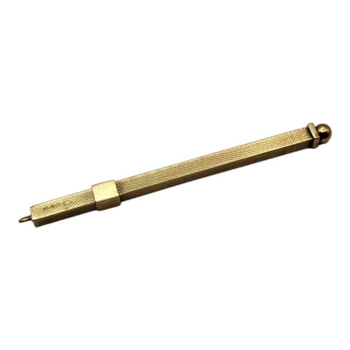 58 - AN EARLY 20TH CENTURY 9CT GOLD TWIZZLE COCKTAIL STICK
Having textured engine turned decoration
(appr... 