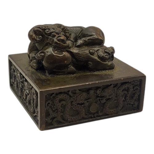 233 - A CHINESE STYLE BRONZE SEAL
With ram and foo dog finial, logographic characters to base.
(dimensions... 