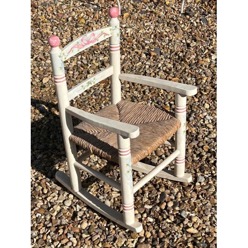 349 - A PAINTED AND FLORAL DECORATION CHILD’S ROCKING CHAIR
With rush seat, along with a French decorative... 