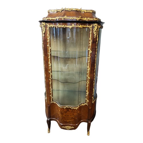 332 - A 19TH CENTURY FRENCH MAHOGANY AND GILT BRONZE MOUNTED VITRINE
The two serpentine glazed doors enclo... 