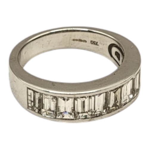 79 - AN 18CT WHITE GOLD AND DIAMOND HALF ETERNITY RING
Having a row of baguette cut stones in a plain des... 