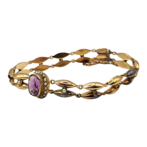 97 - AN EARLY 20TH CENTURY YELLOW METAL,AMETHYST AND SEED PEARL BRACELET
The central oval cut amethyst ed... 