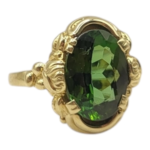 13 - A VINTAGE 14CT GOLD AND PERIDOT RING
Having an oval cut faceted stone in an unusual floral design mo... 