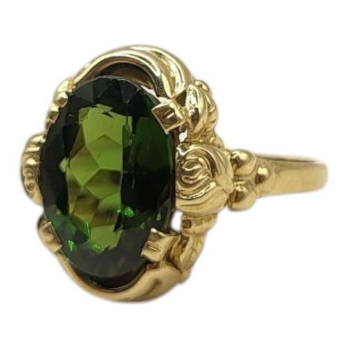 13 - A VINTAGE 14CT GOLD AND PERIDOT RING
Having an oval cut faceted stone in an unusual floral design mo... 