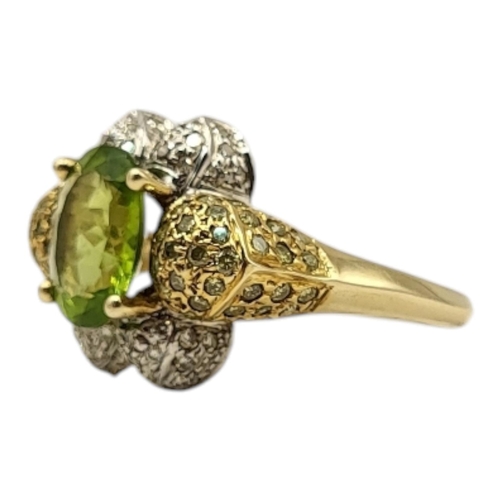 16 - A VINTAGE 14CT GOLD PERIDOT, DIAMOND AND COGNAC DIAMOND RING
The oval cut peridot set with yellow di... 