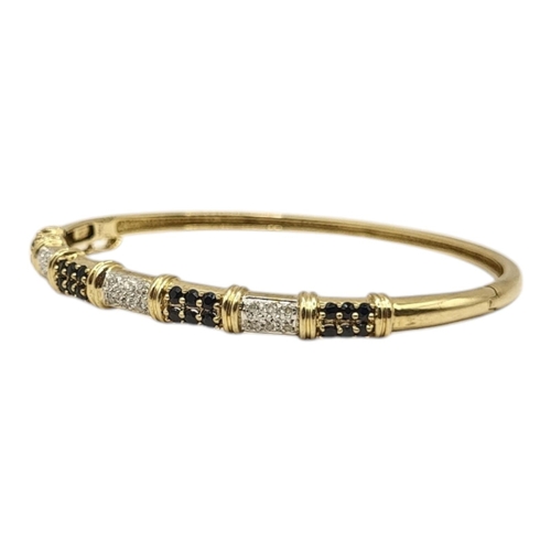 3 - A 9CT GOLD, SAPPHIRE AND DIAMOND BANGLE
Having arrangement of six sapphires interspersed with six di... 