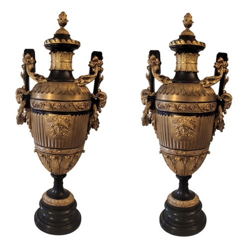 254 - A PAIR OF GRECIAN STYLE BRONZE AND GILT AMPHORA URNS
With a pineapple finial sitting above a fluted ... 