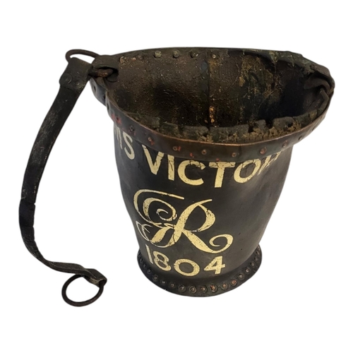 259 - A GEORGIAN LEATHER AND COPPER BANDED SHOT BUCKET
With HMS Victory and GR insignia 1804 later applied... 