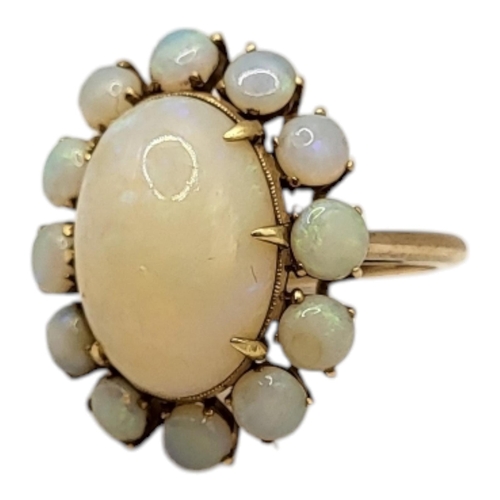 1 - A VINTAGE YELLOW METAL AND OPAL RING
The central oval cut opal edged with round cut opals.
(central ... 