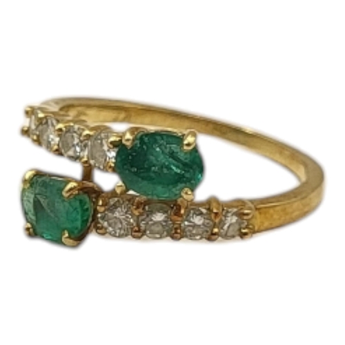 2 - A VINTAGE YELLOW METAL EMERALD AND DIAMOND RING,two oval cut emeralds set with graduated round cut d... 