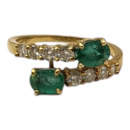 2 - A VINTAGE YELLOW METAL EMERALD AND DIAMOND RING,two oval cut emeralds set with graduated round cut d... 