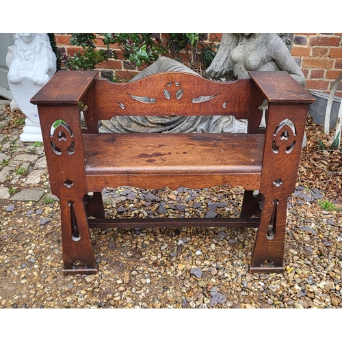 358 - AN ARTS AND CRAFTS OAK PEW having a scrolled back with pierced decoration and Gothic revival design ... 