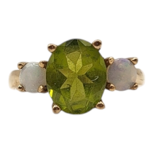 6 - AN EARLY 20TH CENTURY PERIDOT AND OPAL RING 
The central oval cut peridot flanked by round cut stone... 