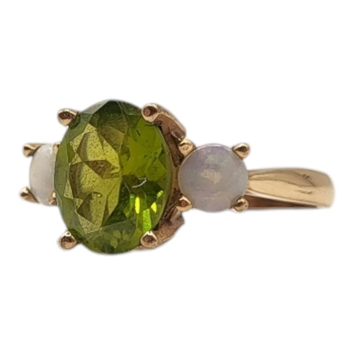 6 - AN EARLY 20TH CENTURY PERIDOT AND OPAL RING 
The central oval cut peridot flanked by round cut stone... 