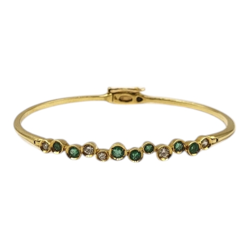 9 - A VINTAGE 18CT GOLD, EMERALD AND DIAMOND BANGLE
Having an arrangement of graduated round cut emerald... 